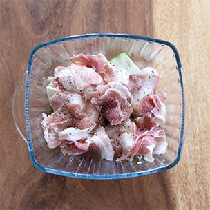 【画像】耐熱皿に、半量のトロなす、豚肉を重ね入れ塩こしょうをする